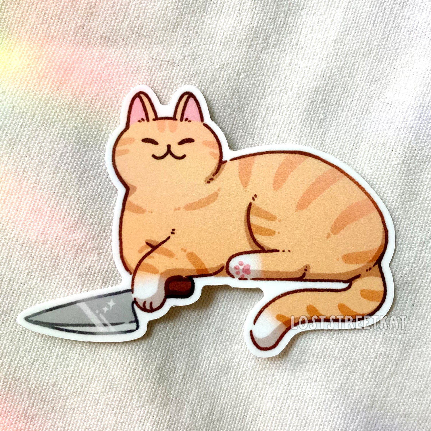 Laying ginger cat with knife in paw vinyl sticker